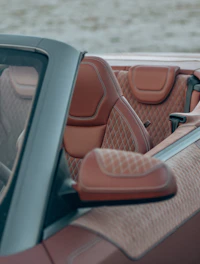 Close-up of luxurious custom Maserati car mats with intricate stitching and rich textures.