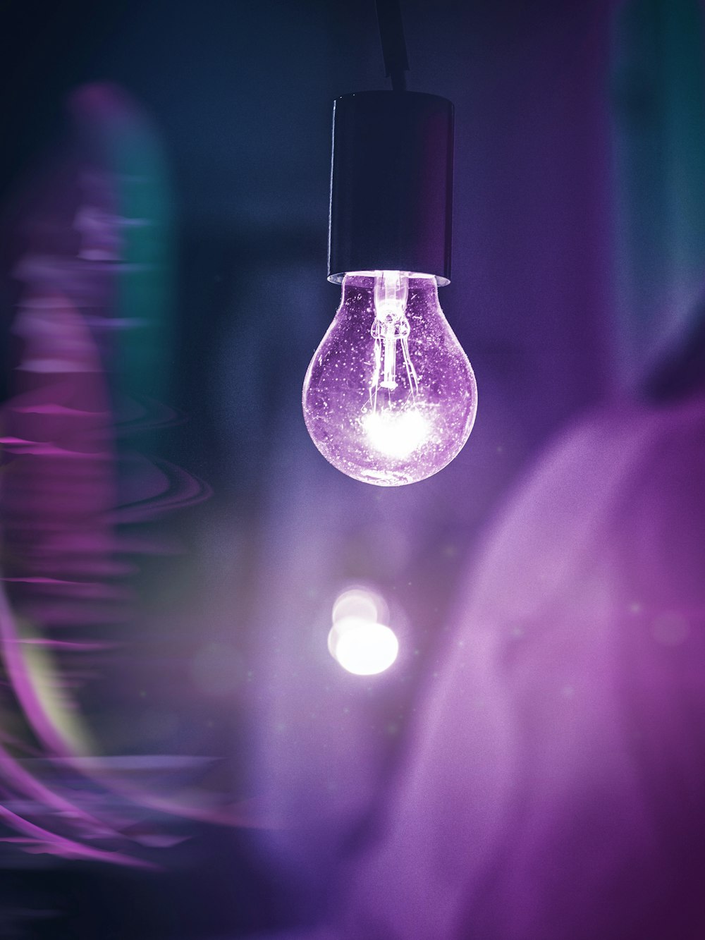 a purple light bulb hanging from a ceiling