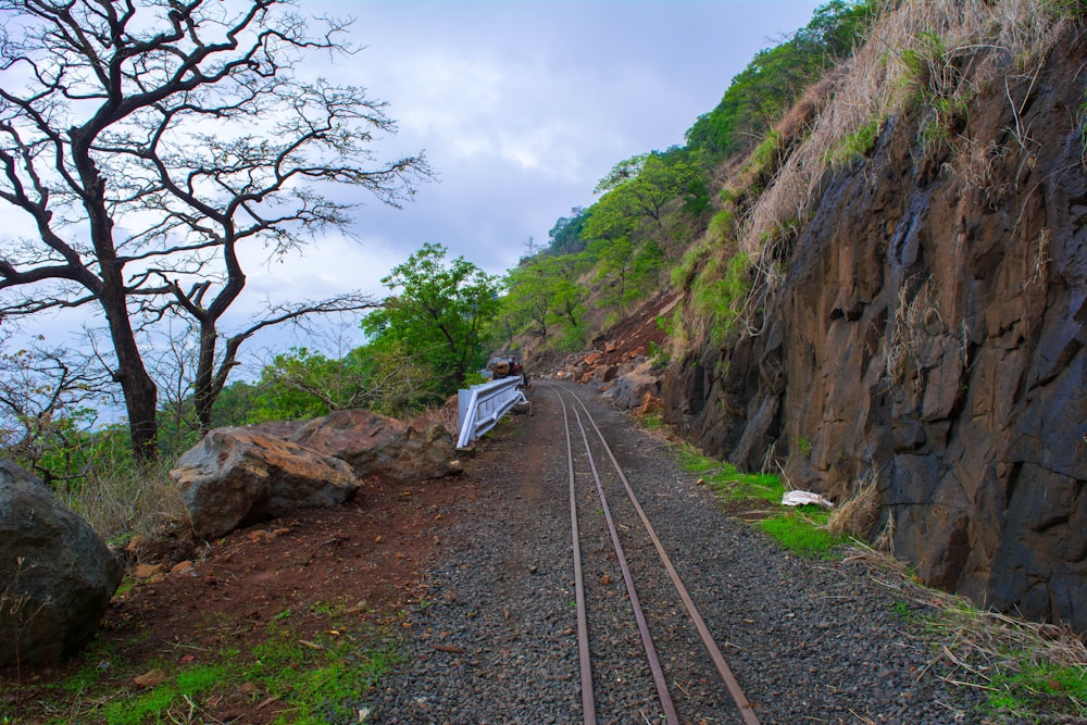 a train track next to a rocky cliff