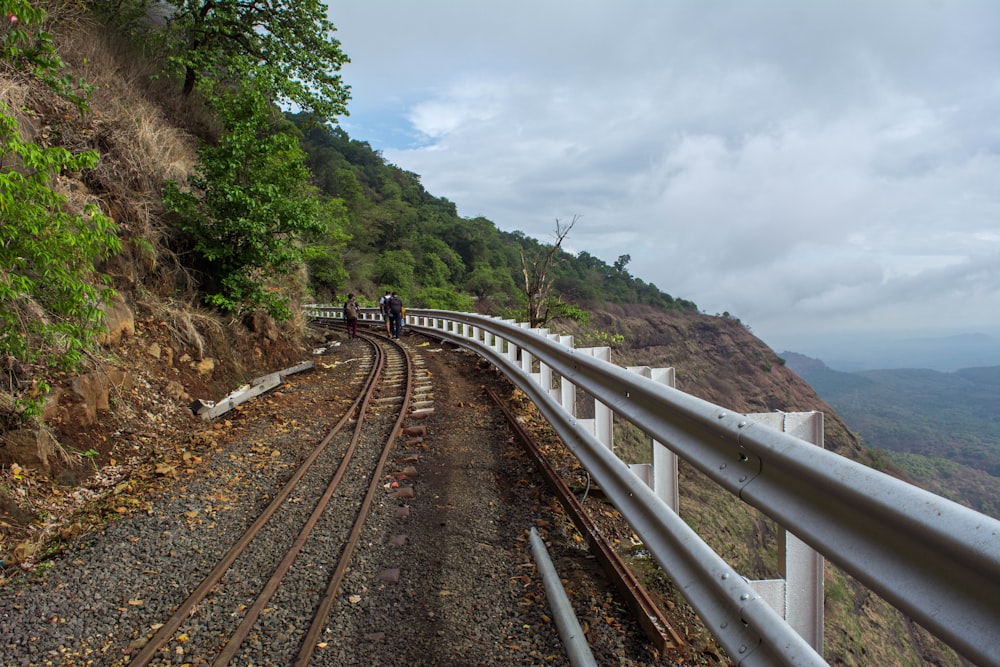 a couple people walking on a train track