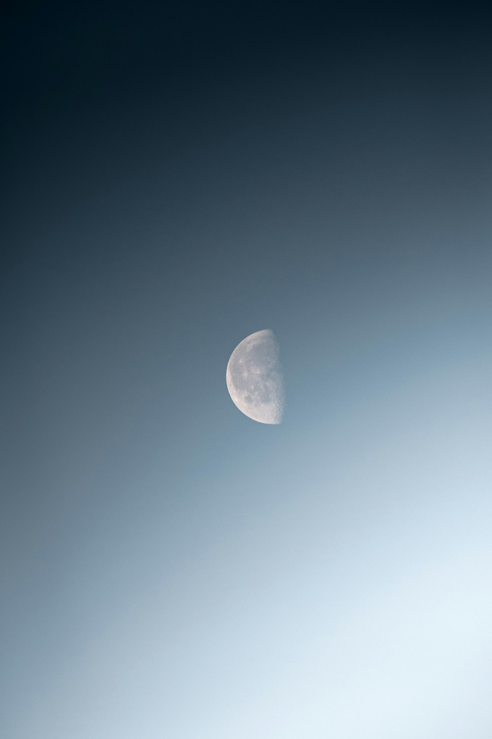 a half moon in a blue sky