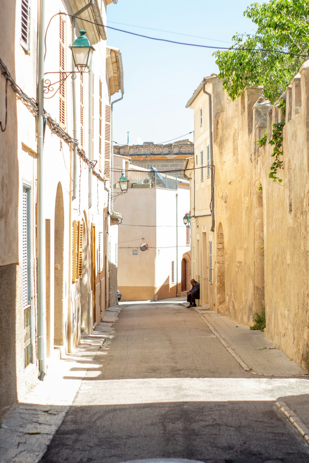 a person walking down a street between buildings