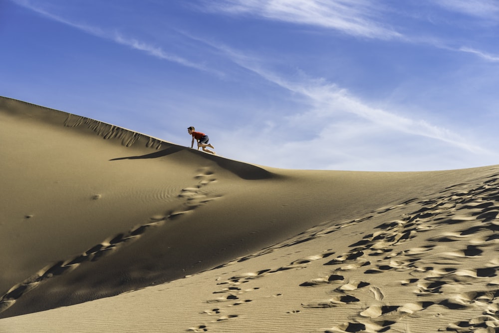 모래 사장에서 낙타를 타는 사람
