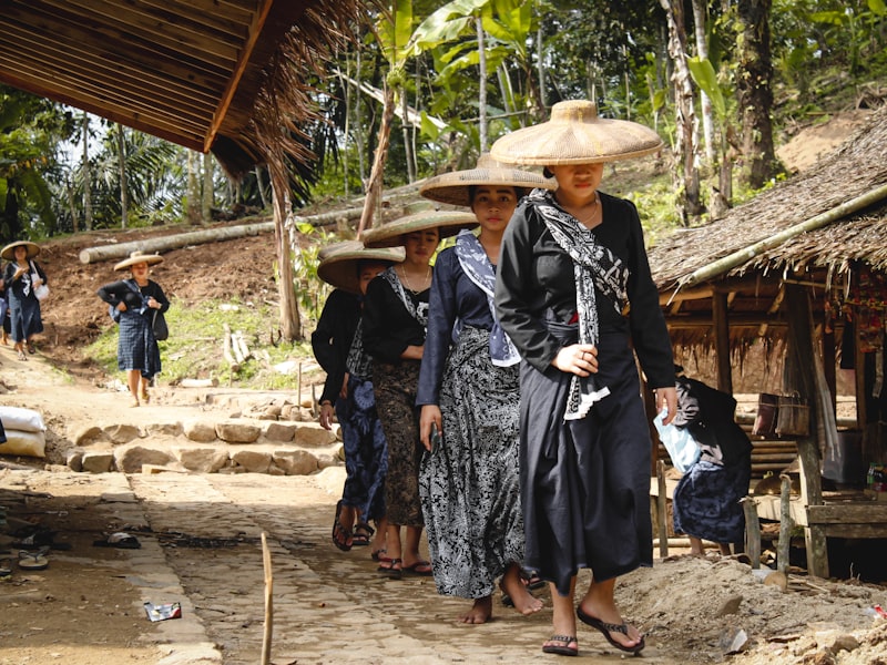 Sekelompok perempuan desa mengenakan caping topi tradisional di desa wisata Indonesia