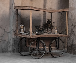 Rustic industrial wine cart made of iron and natural wood displayed in a cozy gourmet area.