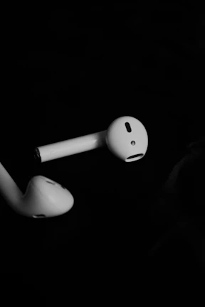 Modern wireless bluetooth earphones with blue and black design displayed on a dark textured surface