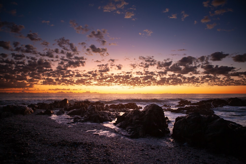 a rocky beach at sunset