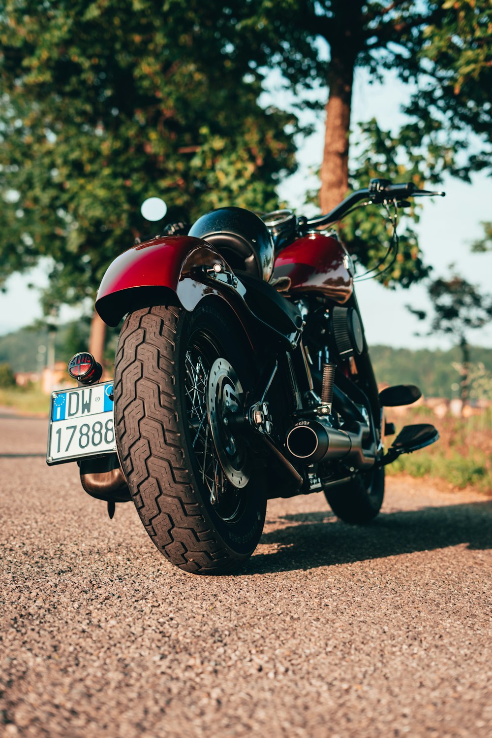 a red motorcycle parked on a dirt road