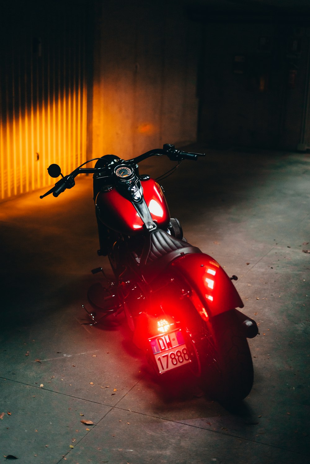 a red scooter parked on a street at night