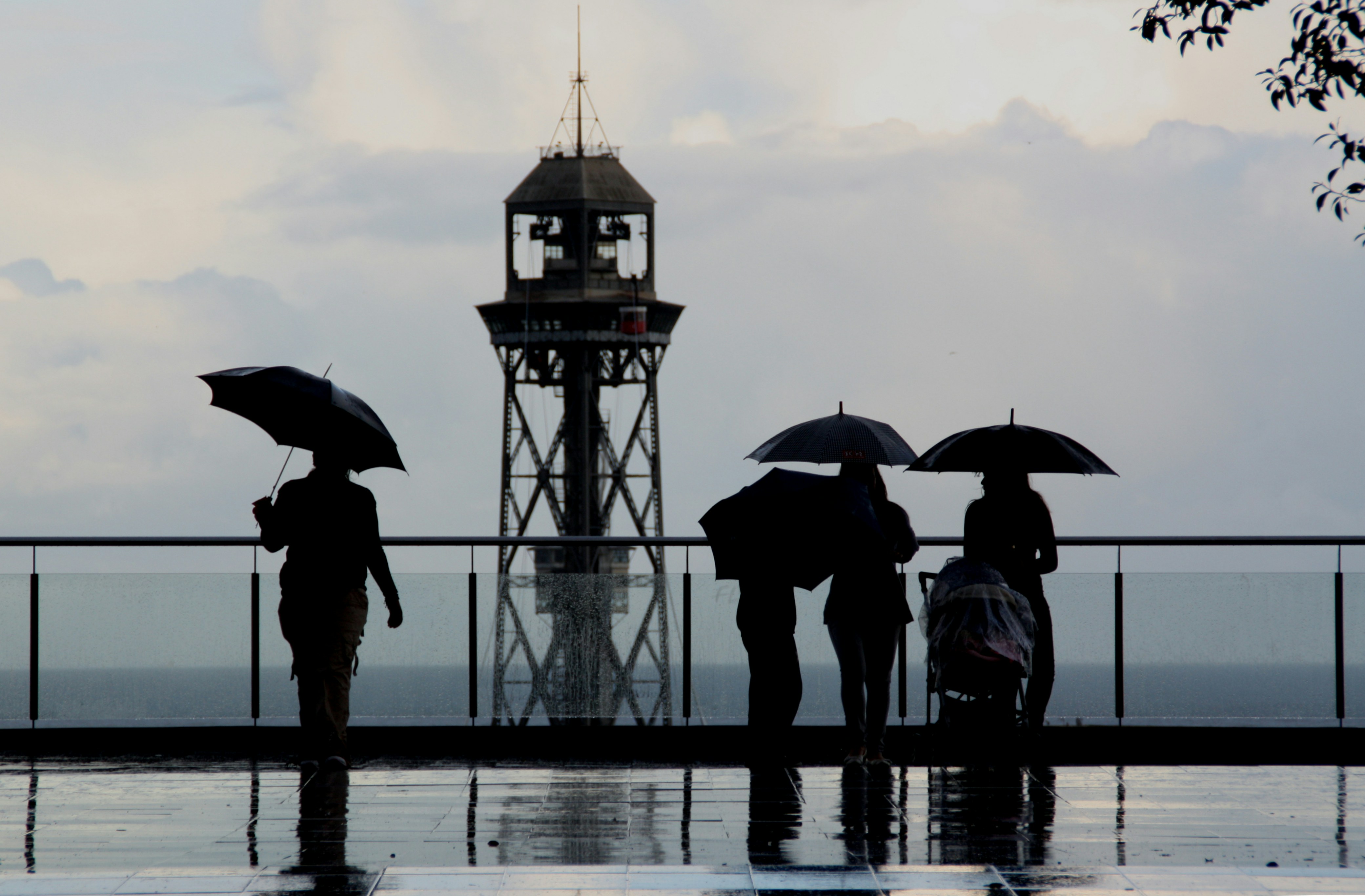 people with umbrellas standing on a pier