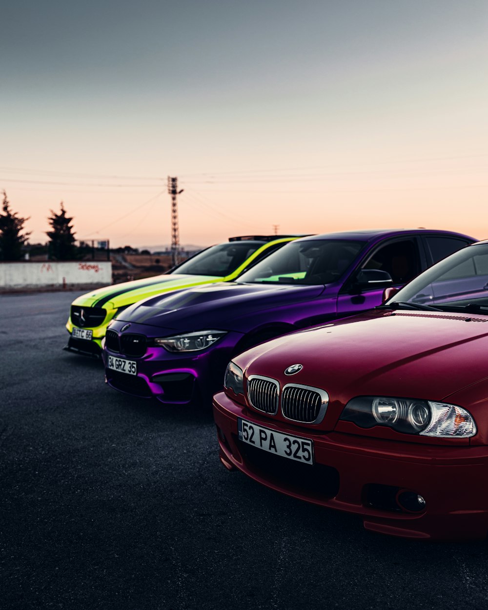 a couple of cars parked next to each other with the sun setting behind them