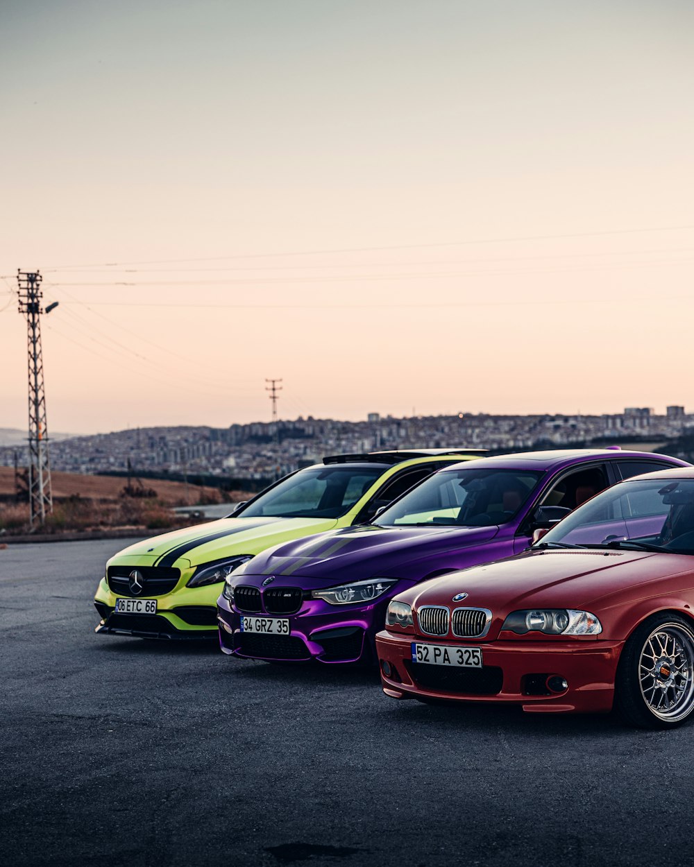 a group of cars parked on a road with a sunset in the background