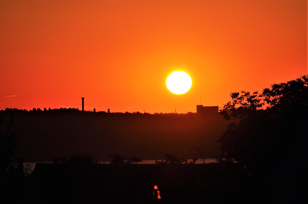 a sunset over a hill