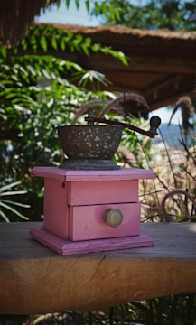 Various coffee grinders on a rustic wooden table.