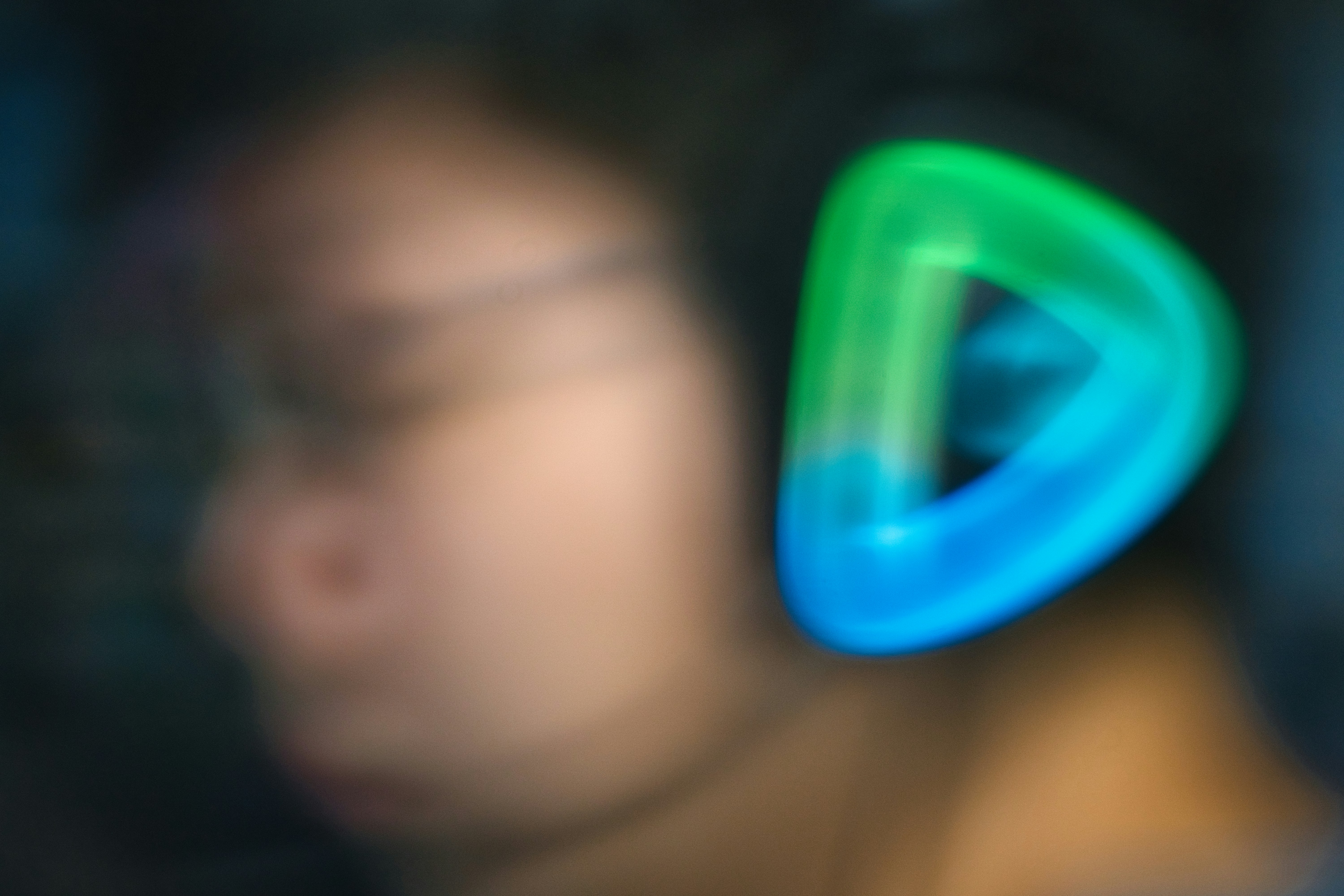 close up of a sleek neural interface band worn on a person's temple, glowing with soft ambient light