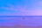 A couple enjoying a serene beach view with clear blue skies and calm waters.
