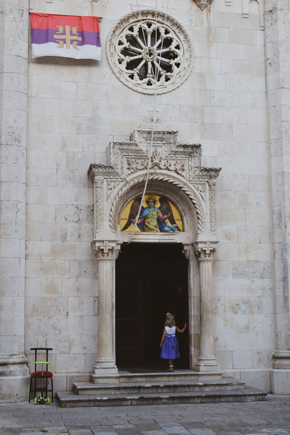 a girl standing in front of a door with a painting on it