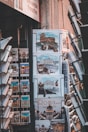 A display of calendars and postcards featuring images of Rome, including pictures of famous landmarks like the Colosseum and cats. The setup appears to be in a shop, with various calendar designs showing Roman architecture and feline imagery.