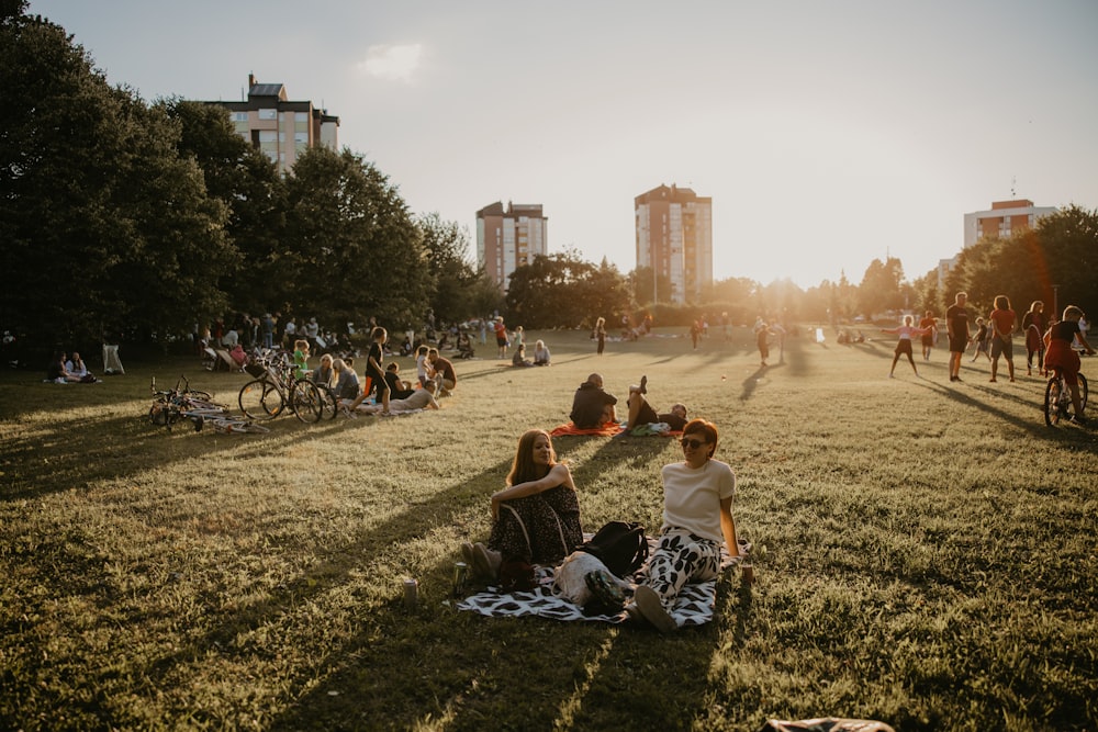 a group of people sitting on the grass