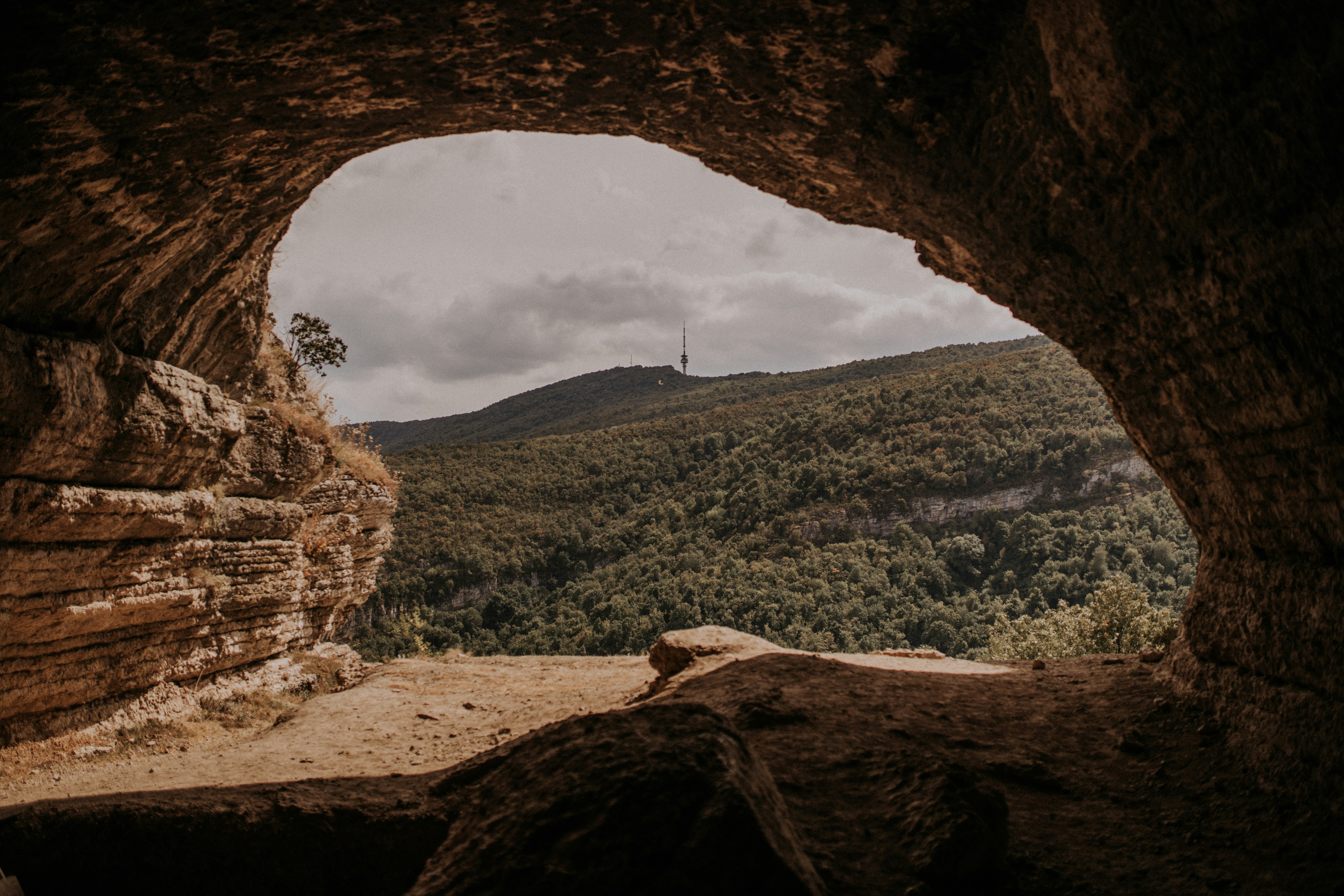 a view of a canyon through a hole in a rock