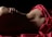 A partial view of a human body in a reclining position, partially covered by a vibrant red fabric. The lighting creates a dramatic contrast, highlighting the curves and contours of the body against a dark background.