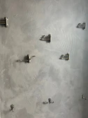 Close-up of jali hooks mounted on a wall, holding various tools efficiently.