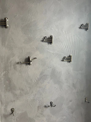 Close-up of jali hooks mounted on a wall, holding various tools efficiently.