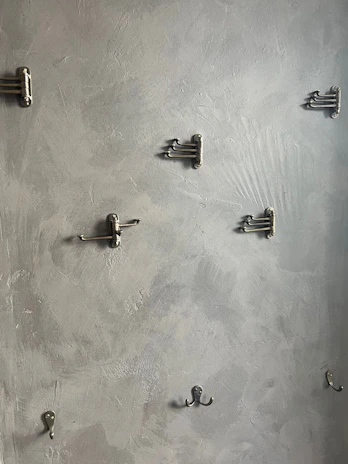 Rustic iron hooks mounted on a textured wall, perfect for organizing tools or keys.