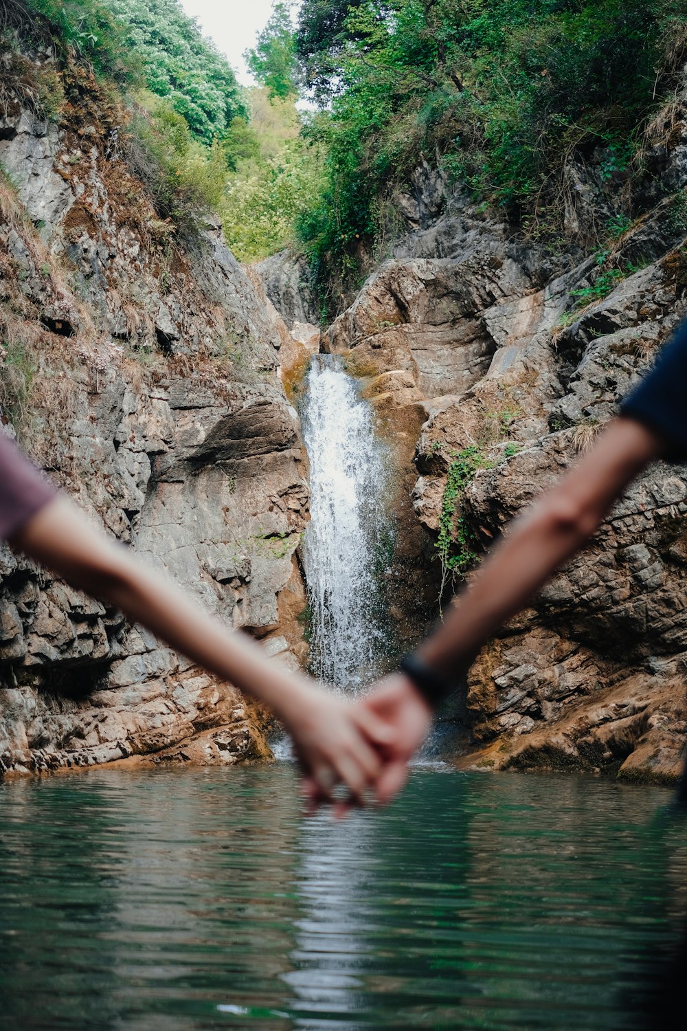 a person touching a waterfall