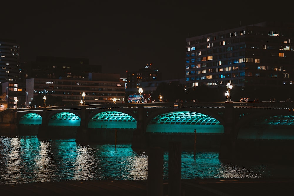 a bridge over a body of water with buildings in the background