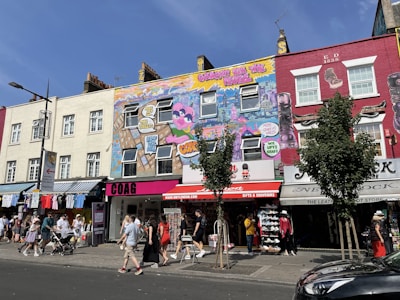 A vibrant city street scene with colorful murals and local shops