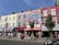 A scenic street view featuring colorful murals and bustling cafes in a lively urban neighborhood.