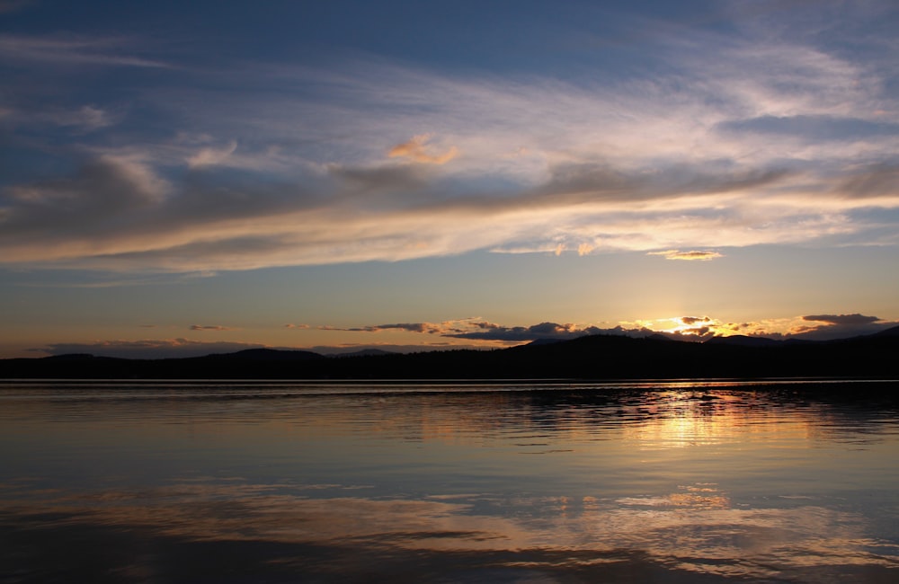 a body of water with mountains in the background