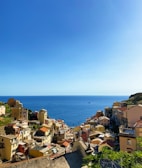 A coastal village with pastel-colored houses under a clear blue sky.