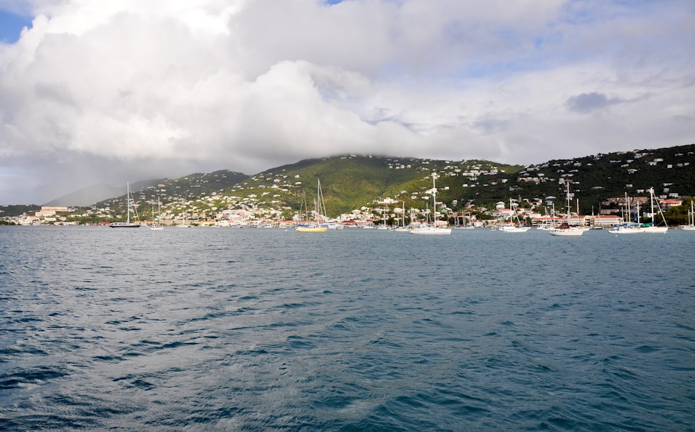 a body of water with boats and a hill in the background