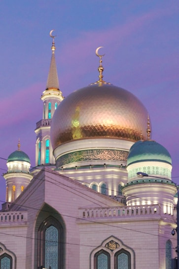 A glowing mosque silhouette at dusk with intertwining patterns and gold accents evoking warmth and unity.