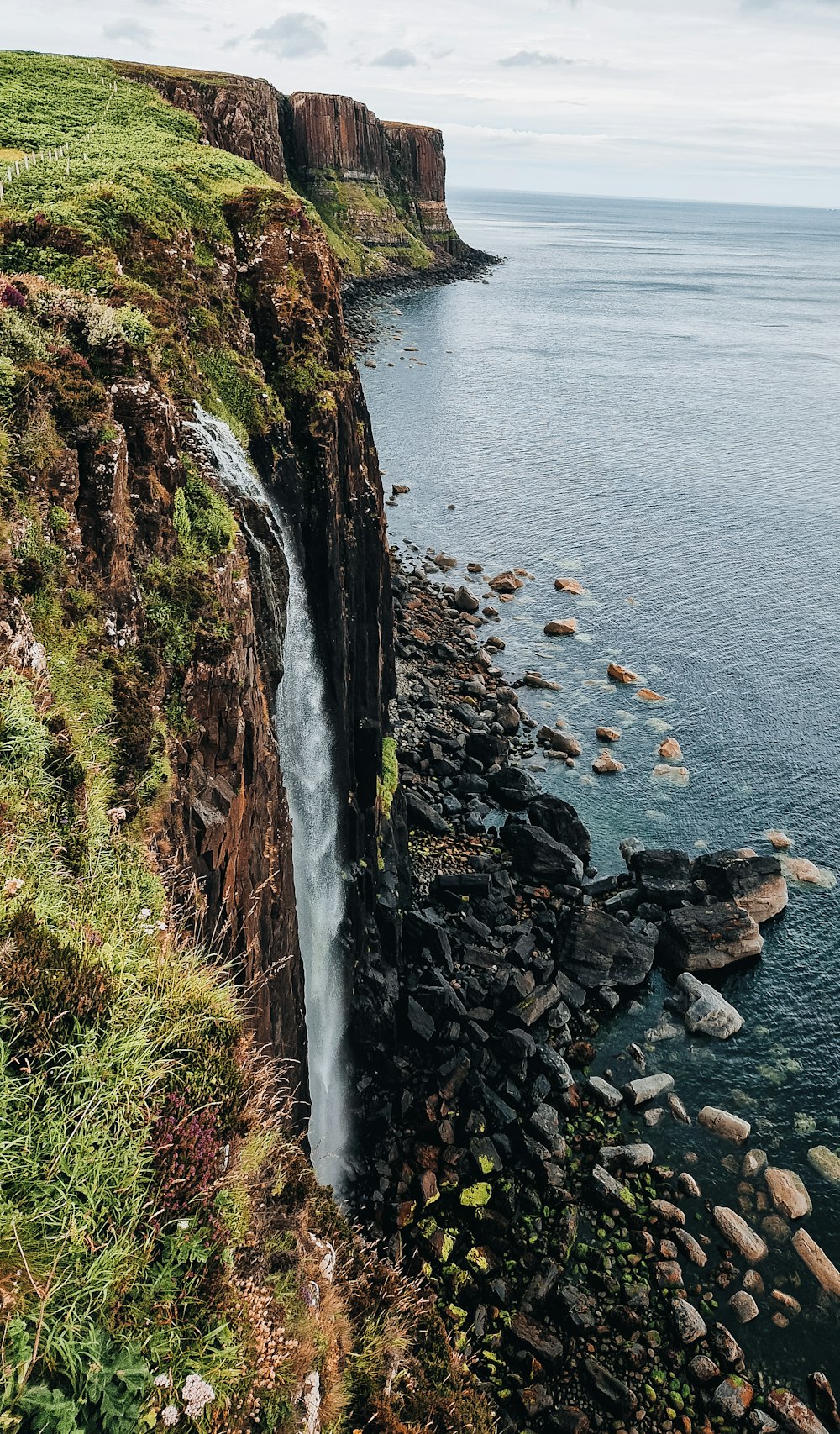 a cliff side with a body of water below