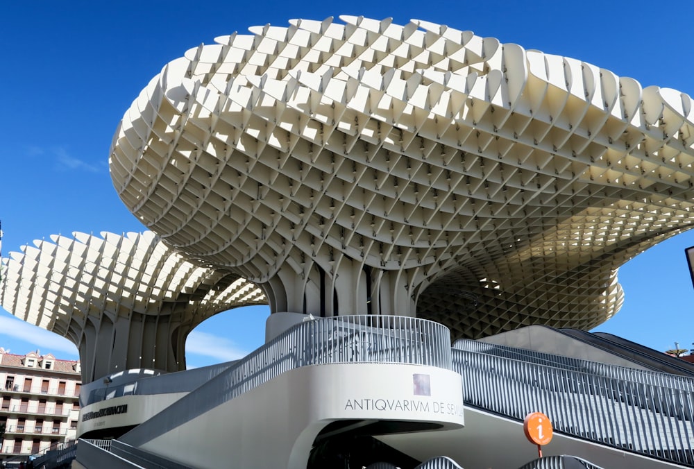 a large building with a curved roof with Metropol Parasol in the background