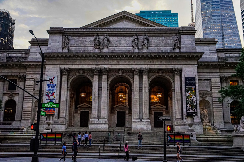 a building with statues and people walking around