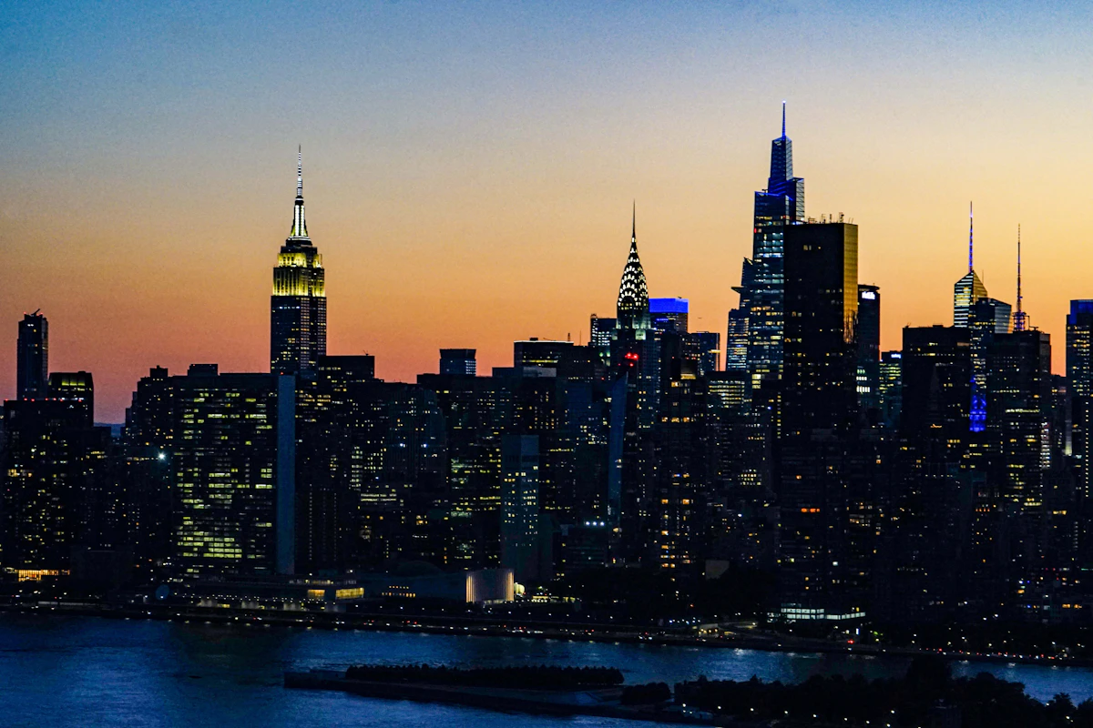 New York City skyline with iconic skyscrapers and Hudson River at dusk