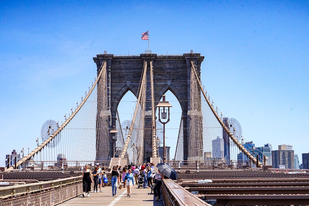 a group of people walking on Brooklyn Bridge