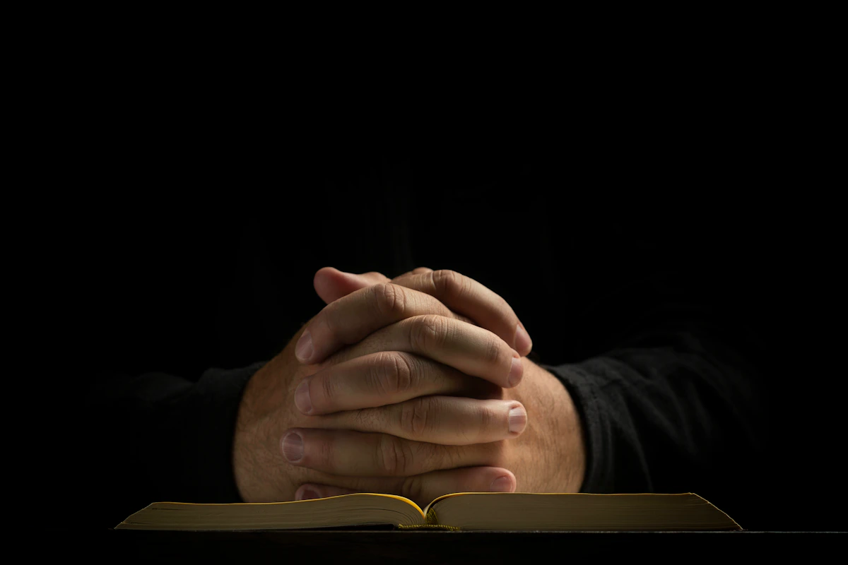 Hands resting on an open Bible