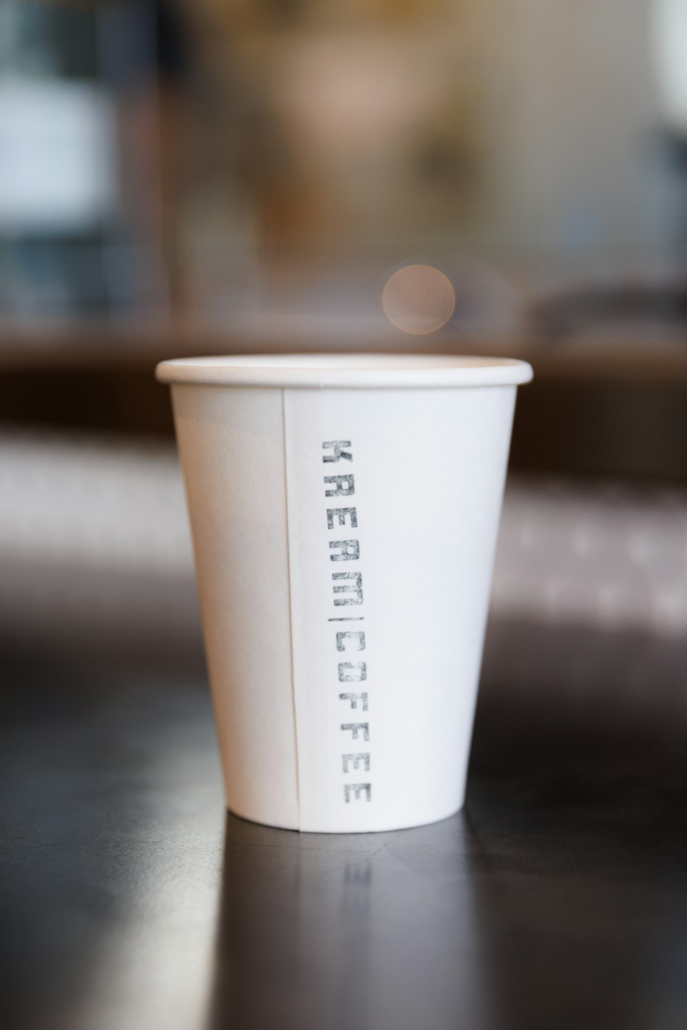 a white cup with a black lid
