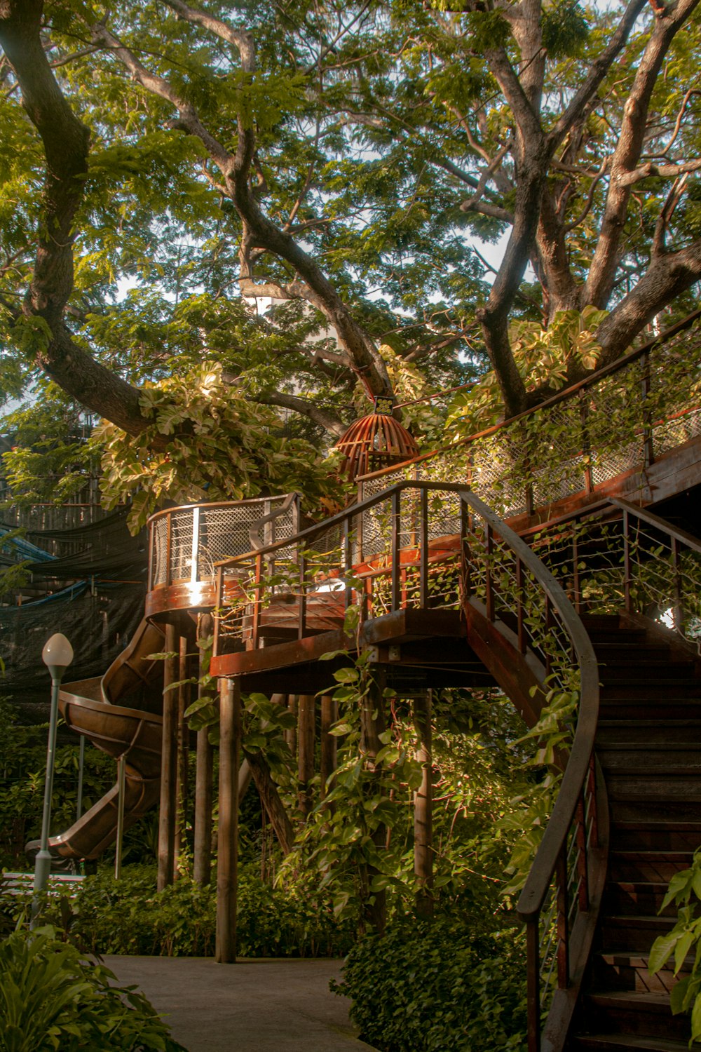 a wooden structure with a hammock and trees in the background