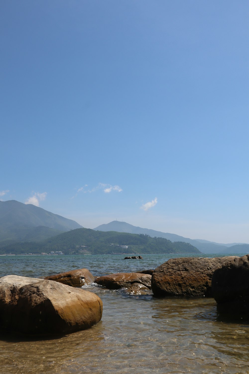 a body of water with rocks and mountains in the background