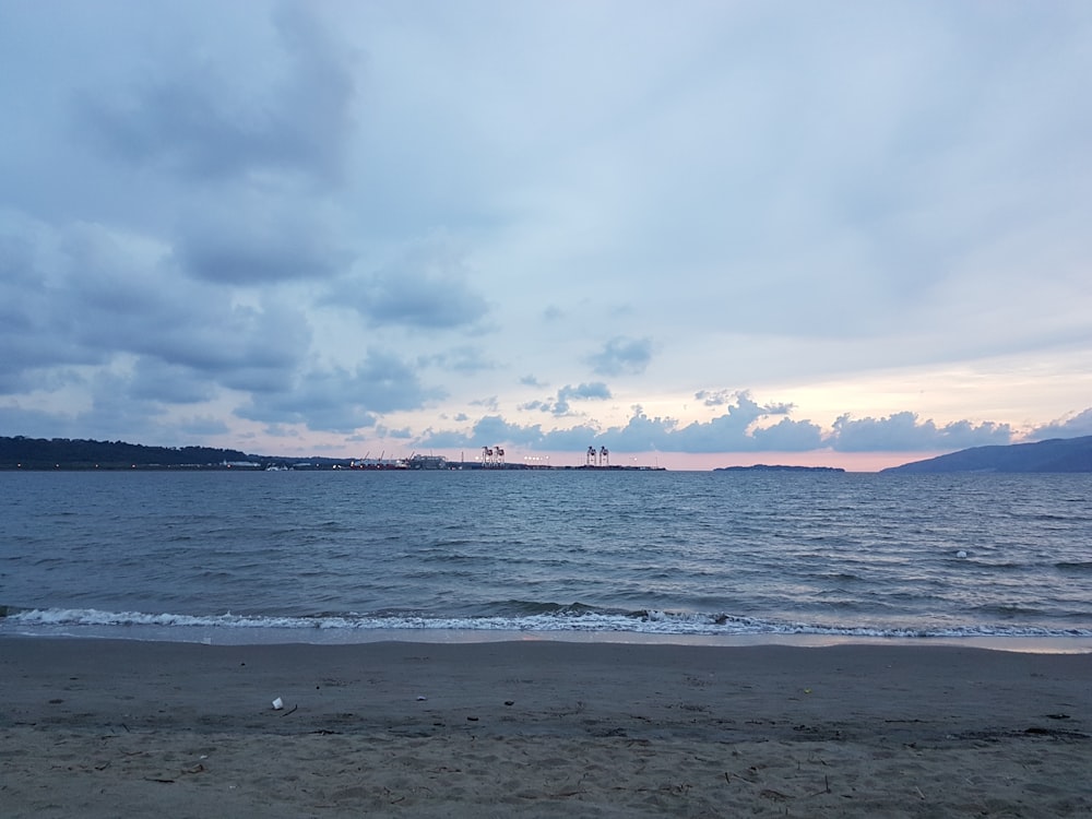 a beach with a body of water and land in the distance