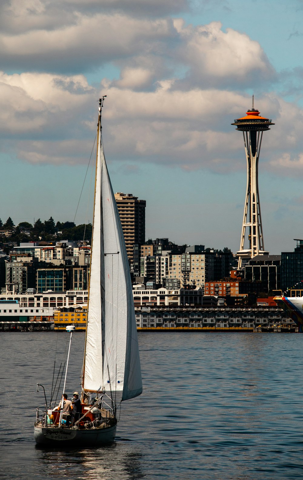 a couple of sailboats in the water with a city in the background