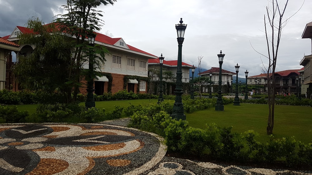 a path with a lamp post and buildings in the background