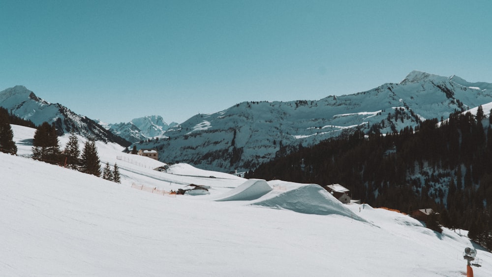 a snowy mountain with trees and buildings