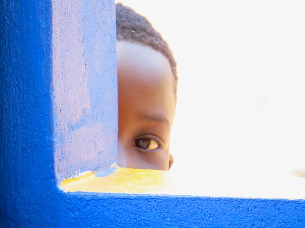 a child looking through a hole in a wall